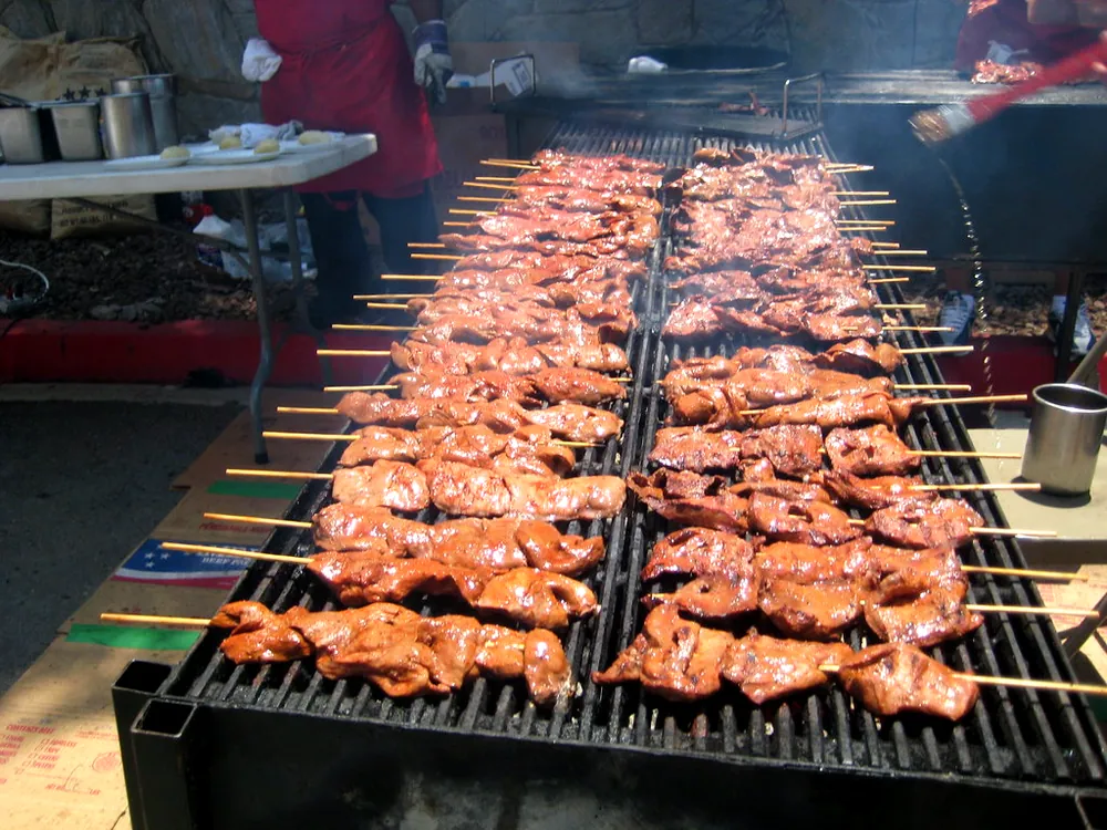 Anticuchos de corazón asándose en la parrilla