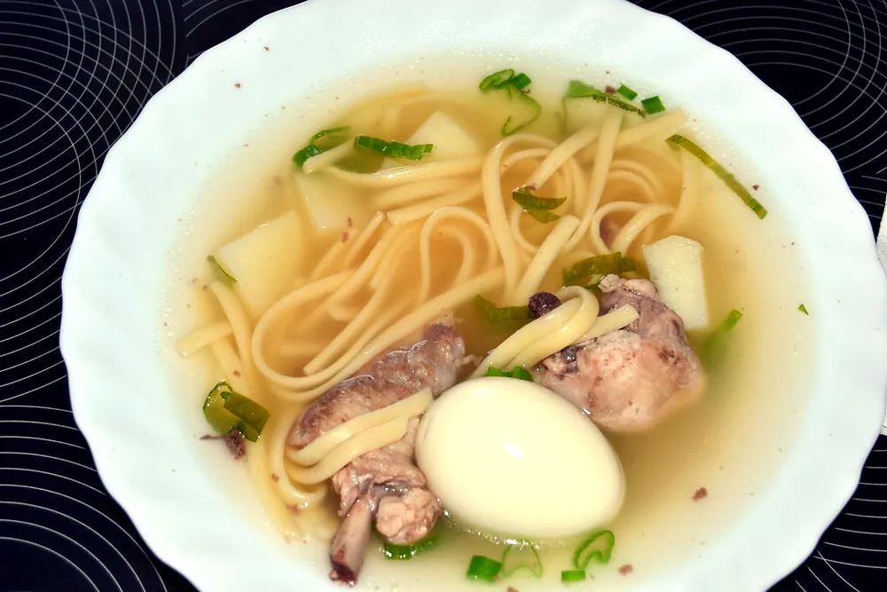 Caldo de gallina con fideo grueso y huevo