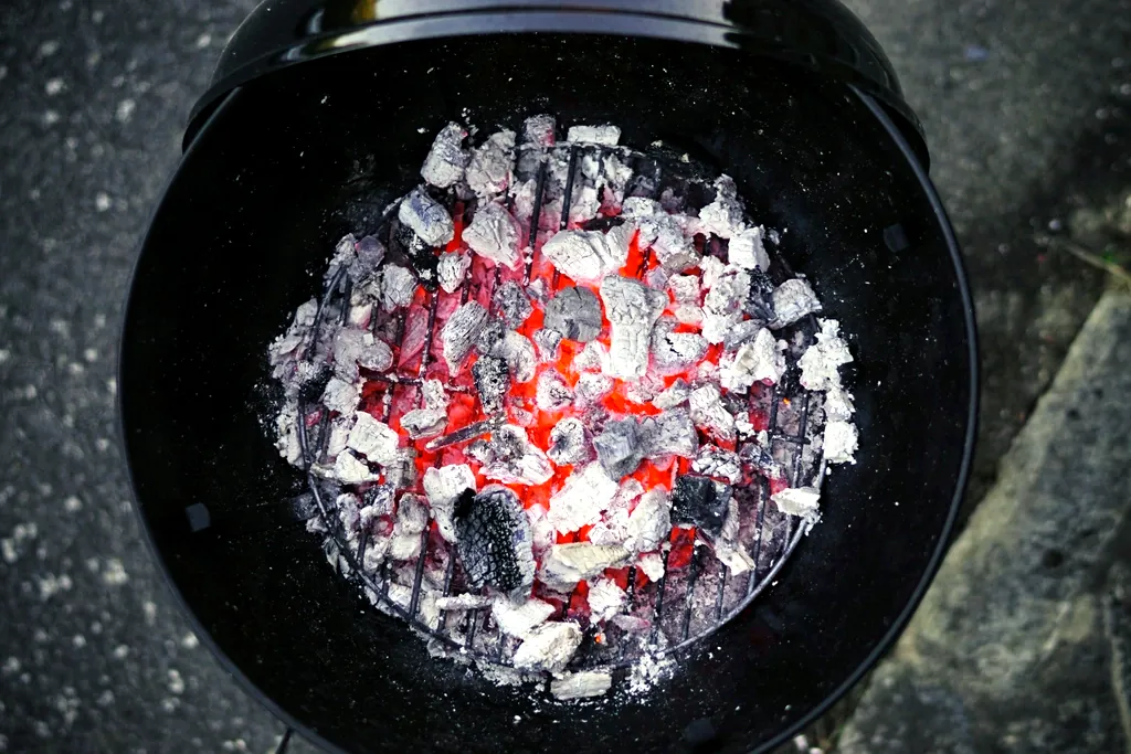 Carbón encendido en la parrilla, listo para el pollo